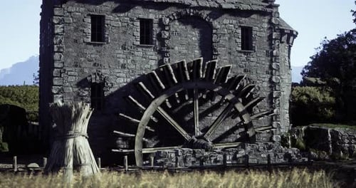 Historic Watermill with Large Wheel Surrounded By Countryside Landscape