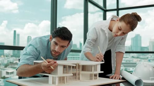 Architects Collaborate on House Model in Modern Office