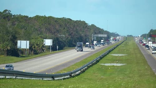 Wide Highway in Florida with Fast Driving Cars During Rush Hour Rising Heat Gives a Shimmering