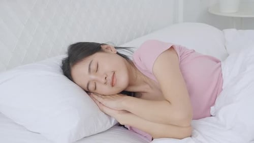 Woman Relaxing Peacefully in Bed at Home
