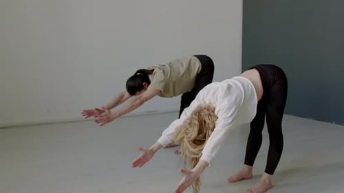 Dance Partners Doing Forward Bend Exercise during Warmup before Rehearsal