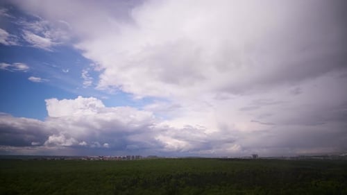 Dramatic Sky Over Forest and City Skyline