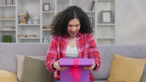 Young Woman Opens Birthday Gift at Home
