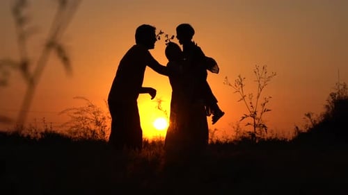 Family Silhouetted Against Vibrant Golden Sunset