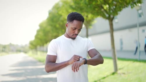 Man Interacts with Smartwatch in Urban Setting