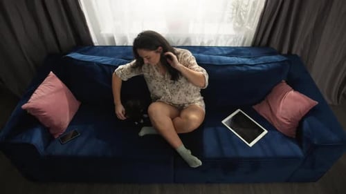 Woman on Couch with Cat and Tablet