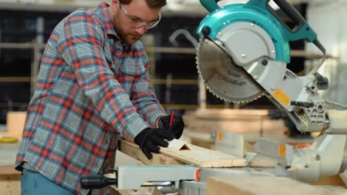 Building Contractor Worker Using Hand Held Worm Drive Circular Saw to Cut Boards on a New Home