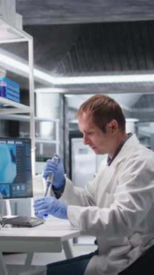 Man Pipetting Blue Liquid in Modern Lab