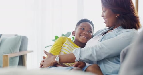 Smiling Child and Woman Cuddling on Couch