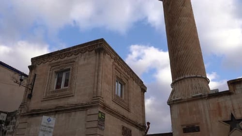 We see the magnificent Kasım Tuğmaner Mosque and its minaret in the old city of Mardin from the lowe