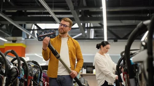 Couple Choosing Vacuum Cleaner in an Electronics Store for New Home