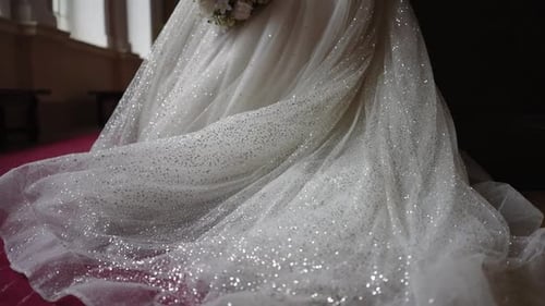 Bride Holding White Rose Bouquet and Wearing Gown