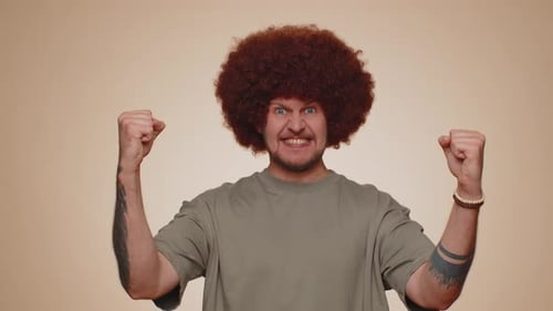 Man with Curly Hair Does Winning Gesture