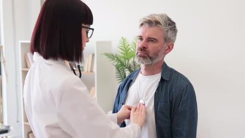 Doctor Listens to Patient Chest with Stethoscope