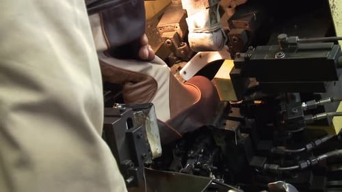 Worker Placing a Boot into a Press Machine in Shoe Factory