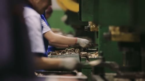 Arbeiter montieren Komponenten manuell in einer Fabrik. Ausrüstung in der Anlage. Gefährlich