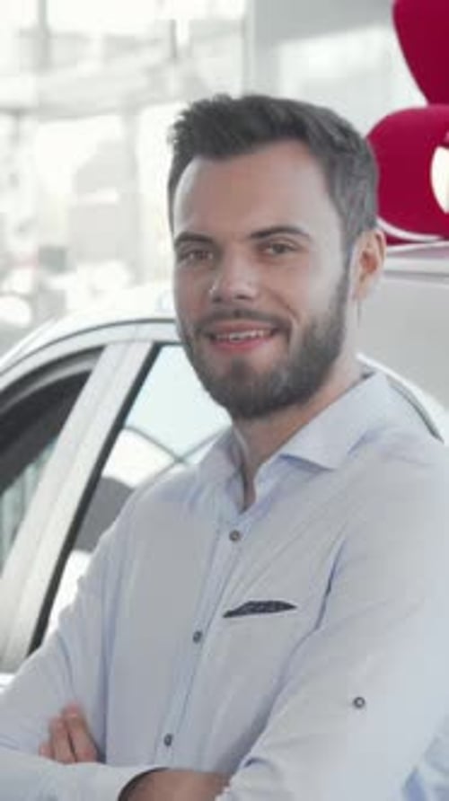 Confident Young Man Proudly Holding Car Keys to His Brandnew Automobile at the Dealership
