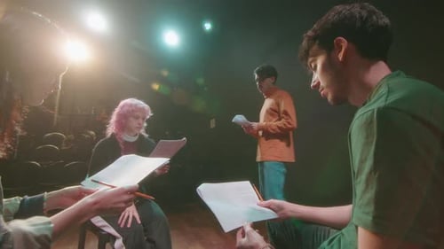 Actors Reading Scripts in Theater under Control of Stage Director