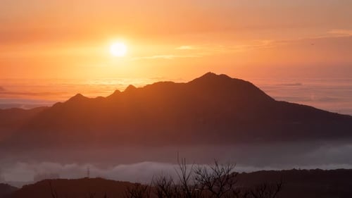 El sol, las montañas y las nubes crean una maravillosa sinfonía al anochecer.