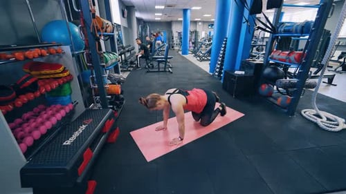 Beautiful woman on mat at gym. Fit young woman doing workout exercise on mat