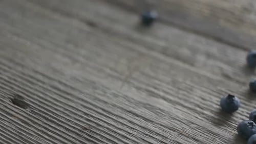 Fresh Blueberries Poured onto Wooden Surface with Spoon