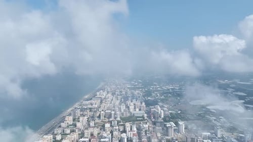 Aerial View Floating Above the Clouds with a Distant View of the City Below