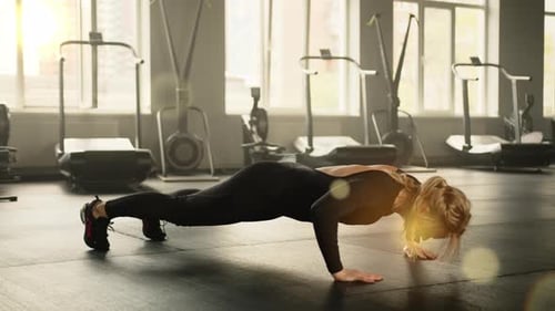 Full Shot of Athletic Blonde Performing Push Ups in Wellequipped Gym