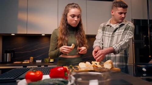 Young Couple Prepares Food Together in Kitchen