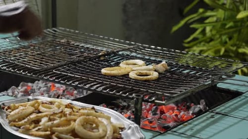 Man Preparing Squid Rings on the Grill