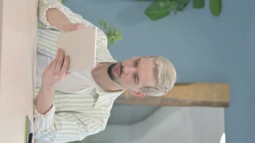 Vertical Video of Young Man Browsing Internet on Tablet in Office