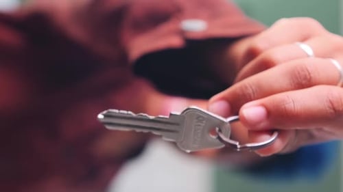 Person Holding Keys in a Close Up Shot