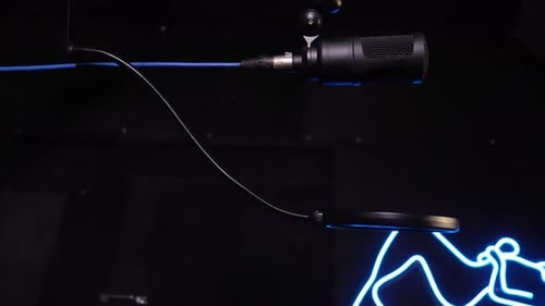 Studio condenser microphone, on background of neon pattern in blue.