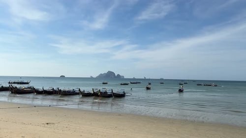 Empty clean beach perfect holiday weather, traditional thai long tail boats