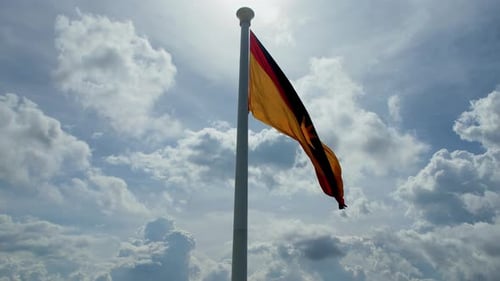 Flag Waving Against Bright Blue Sky with Clouds