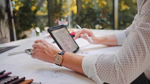 Designer Creating Designs Using Tablet at Desk