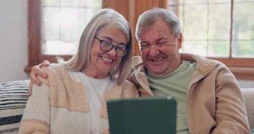 Senior Couple Using Tablet Together on Sofa