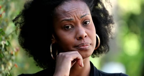 Thoughtful Woman Close-Up Outdoors in Natural Light