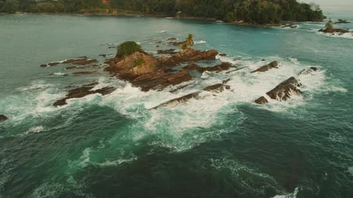 Rocky islets surrounded by turquoise ocean waves near coastline in Costa Rica