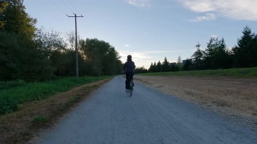 Adventure Woman Bike Riding on a Bicycle Trail Surrounded By Green Trees
