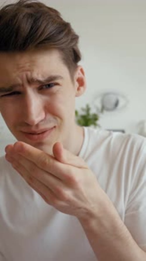 Vertical of Shocked Young Man Grimaces Refusing to Look in Camera