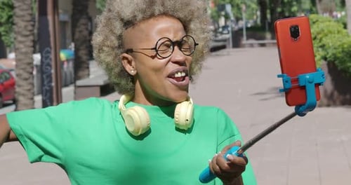 African American Young Woman Influencer on the Street Recording a Video with a Smart Phone