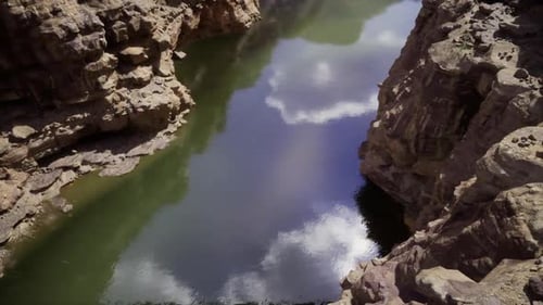Escena tranquila del lago rodeada de acantilados rocosos y un ambiente tranquilo