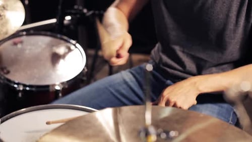 Drummer plays drums and cymbals in a studio