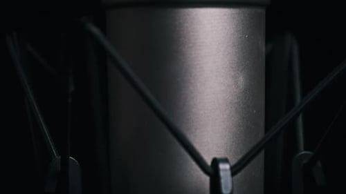 Le microphone de studio pivote sur un fond noir en gros plan
