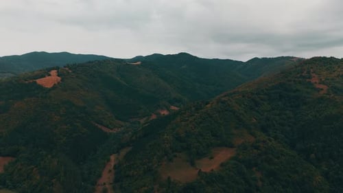 An Aerial View Capturing the Lush Green Hills on a Beautifully Cloudy Day in Nature
