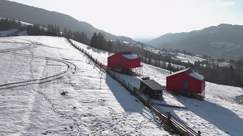 Red Cabins on a Snowy Hillside Remote Winter Retreat with Panoramic Mountain Views Wooden Fences and