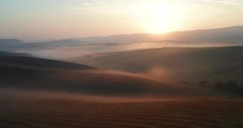 Aerial shot of scenic panoramic misty view of Italian hills at a sunrise.