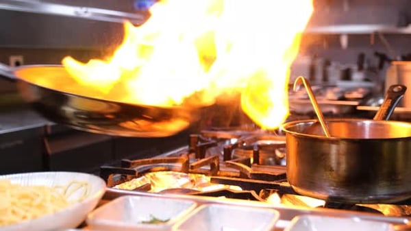 Close-up of a Restaurant Chef Cooking Food on Fire in the Restaurant ...