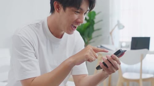 Young Man Using Smartphone in Modern Home
