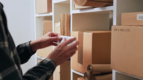 Activité entrepreneuriale, Employé d'un magasin d'emballage Coller de manière responsable un code-barres sur une boîte en carton